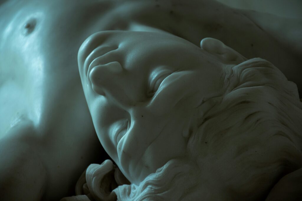 Close-up of a marble sculpture with detailed chiseling in low light, evoking Renaissance artistry.